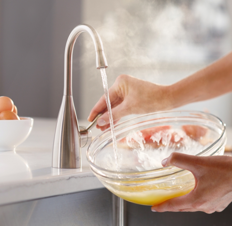 Faucet filling a glass bowl.