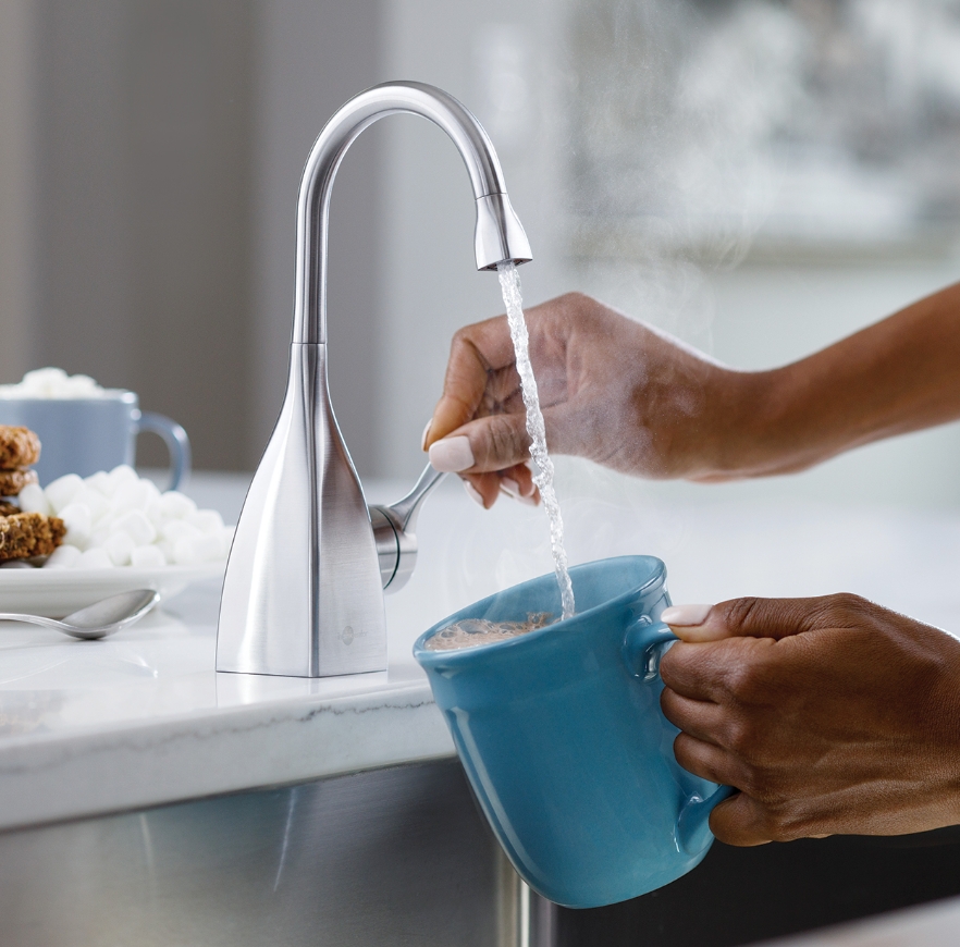 Hot water faucet filling a mug.