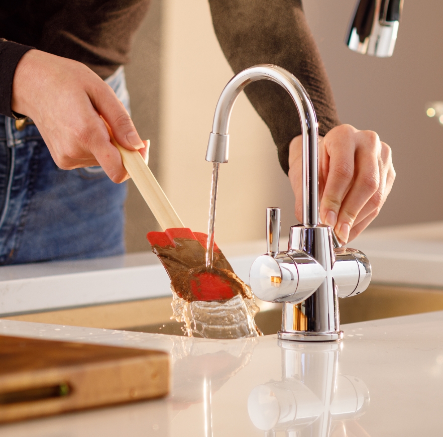 Faucet rinsing a spatula.