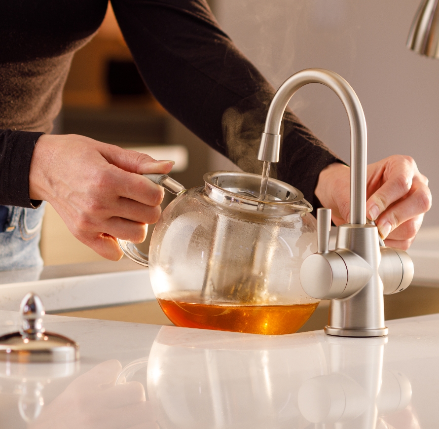 Faucet filling a glass pitcher.