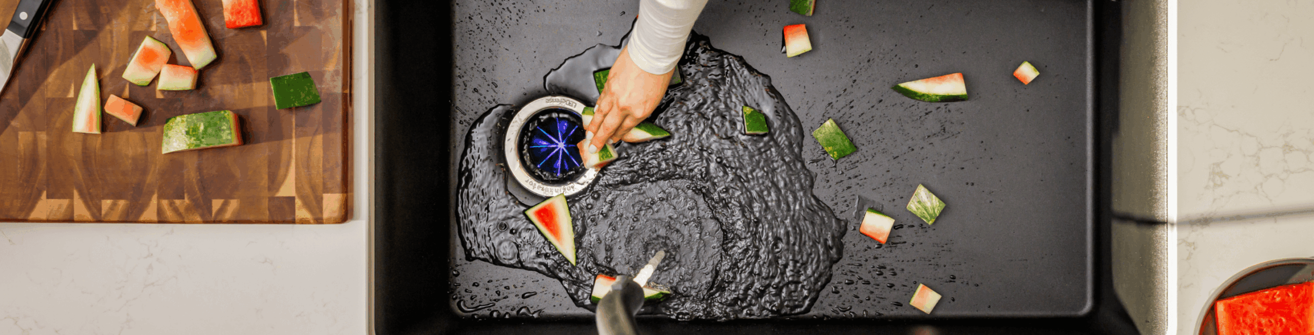 Kitchen sink with the LED disposal grinding cut up watermelon rind.